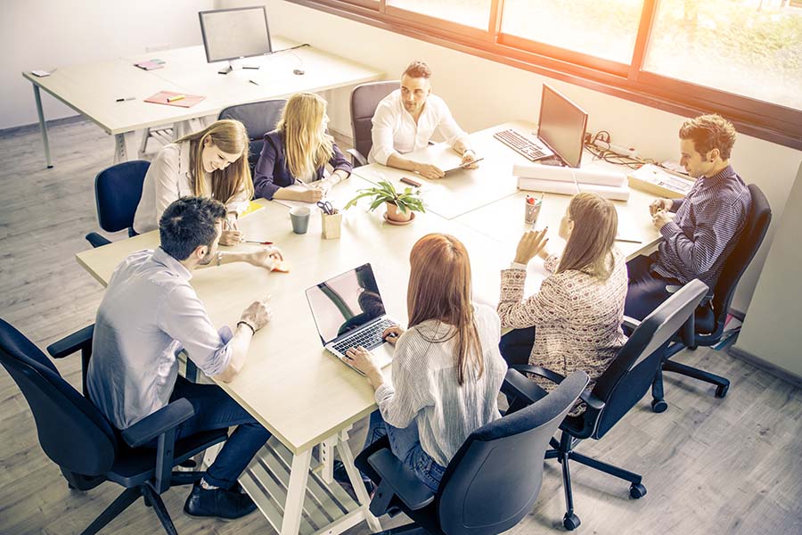 Business Insurance - Group Of Employees Sitting At Table Discussing Business Agenda